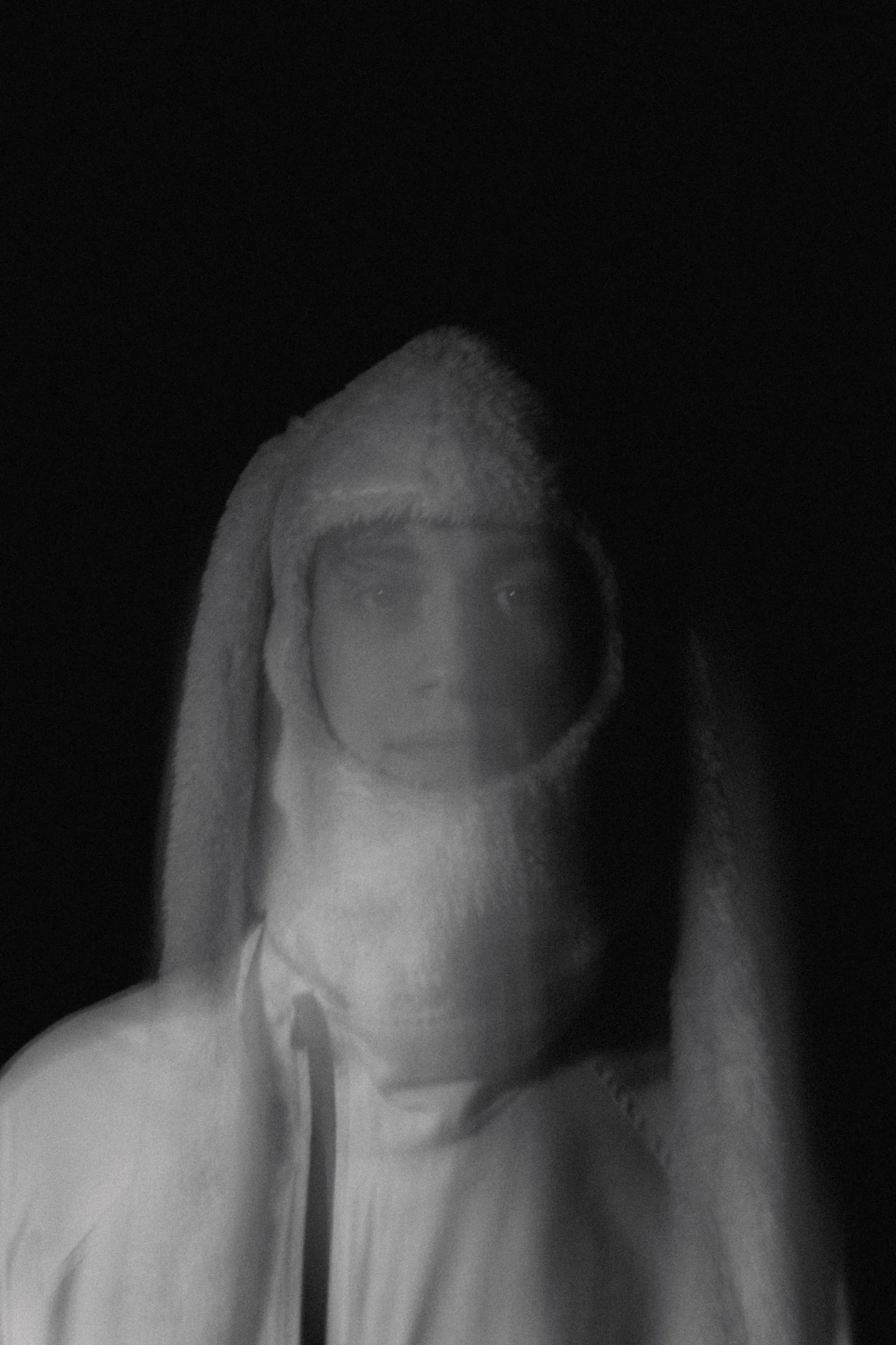 Dobre exposición borrosa dun rostro encapuchado en branco e negro